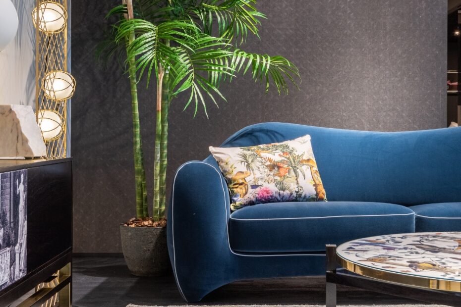 Sofá de luxo moderno com acabamento em veludo e pés metálicos, em um ambiente sofisticado.