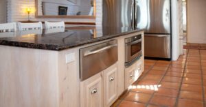Cozinha gourmet compacta e moderna com eletrodomésticos planejados e detalhes sofisticados.