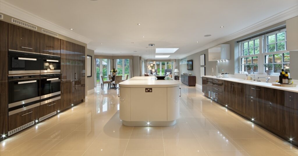 Cozinha de luxo moderna com painéis minimalistas. Uma porta oculta se revela, levando a uma segunda cozinha de trabalho, a nova tendência de design.