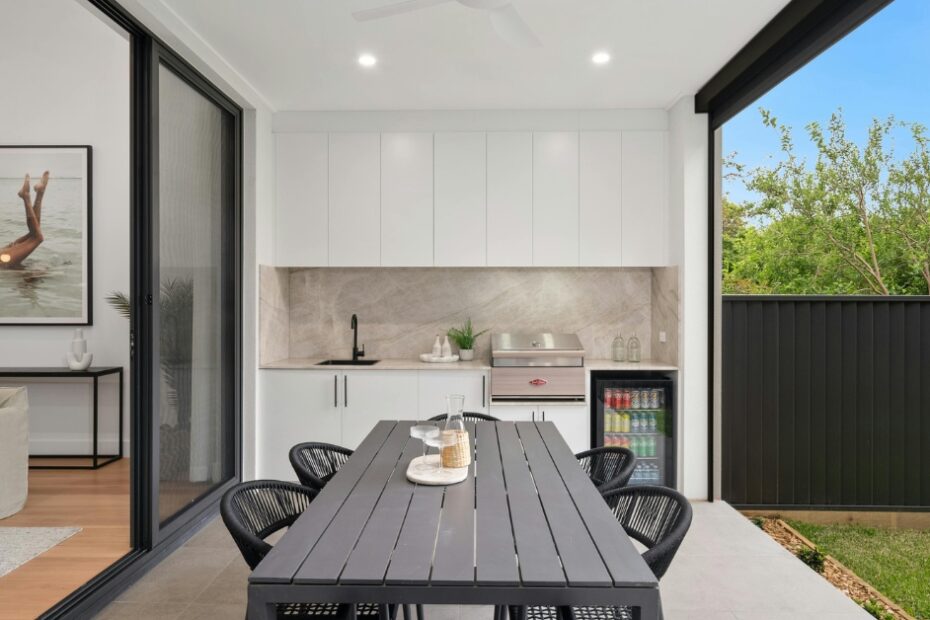 Varanda gourmet pequena decorada com móveis planejados, iluminação sofisticada e plantas em jardim vertical.