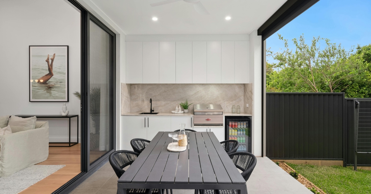 Varanda gourmet pequena decorada com móveis planejados, iluminação sofisticada e plantas em jardim vertical.