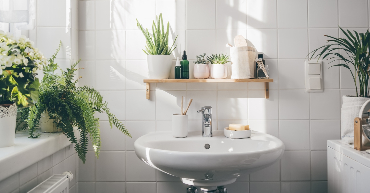 Decoração de banheiro moderna e funcional com revestimentos claros, iluminação estratégica e móveis planejados.