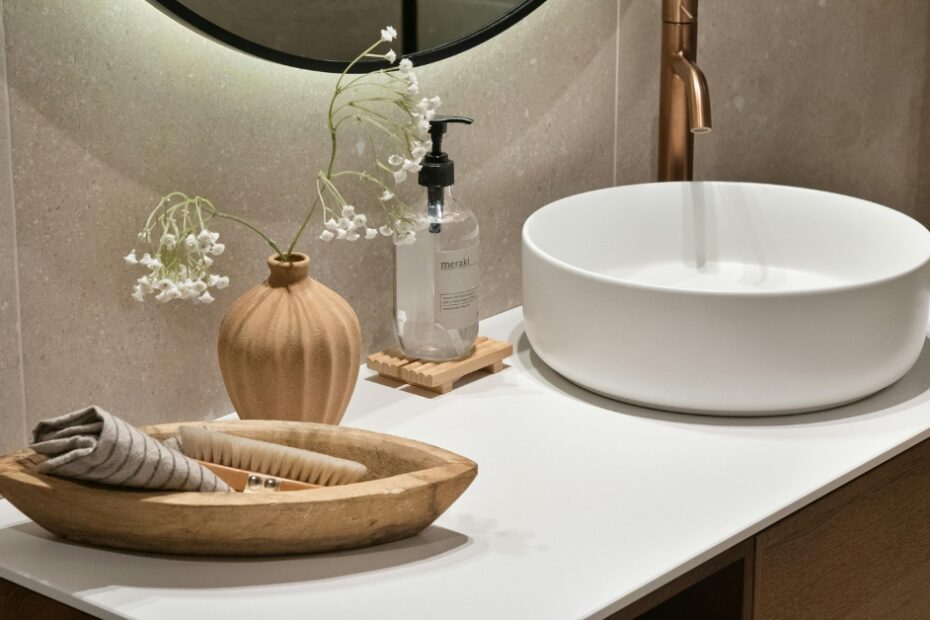 Cena de banheiro moderno com cuba de apoio branca, torneira preta e espelho redondo, destacando o design da cuba e pia para banheiro.