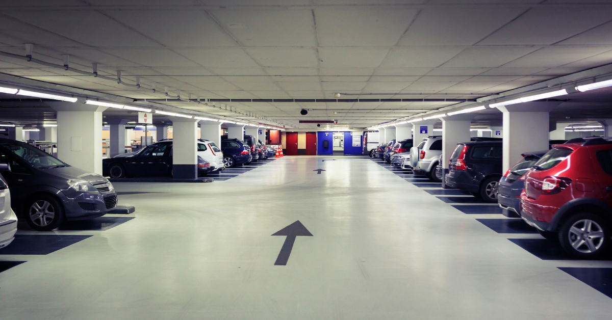 Garagem moderna com paisagismo exibindo um piso para area externa garagem antiderrapante em pedra natural, destacando resistência e estética visual.