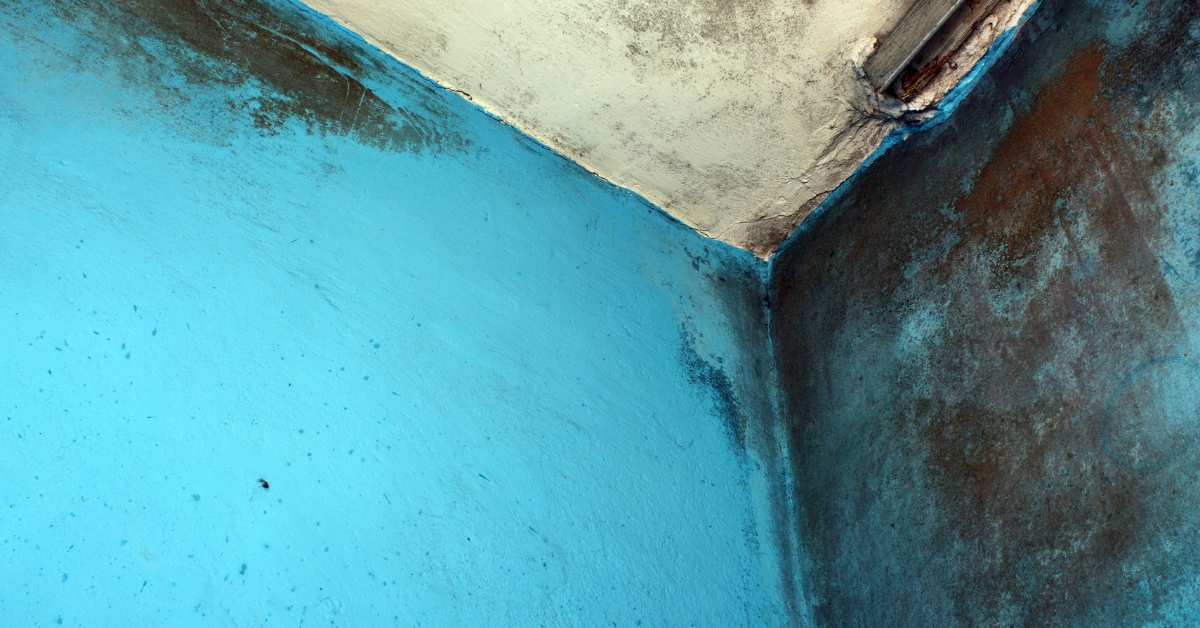 Quarto de luxo arejado com roupa de cama branca e janela aberta, ilustrando o resultado do protocolo sobre como tirar cheiro de mofo do quarto.