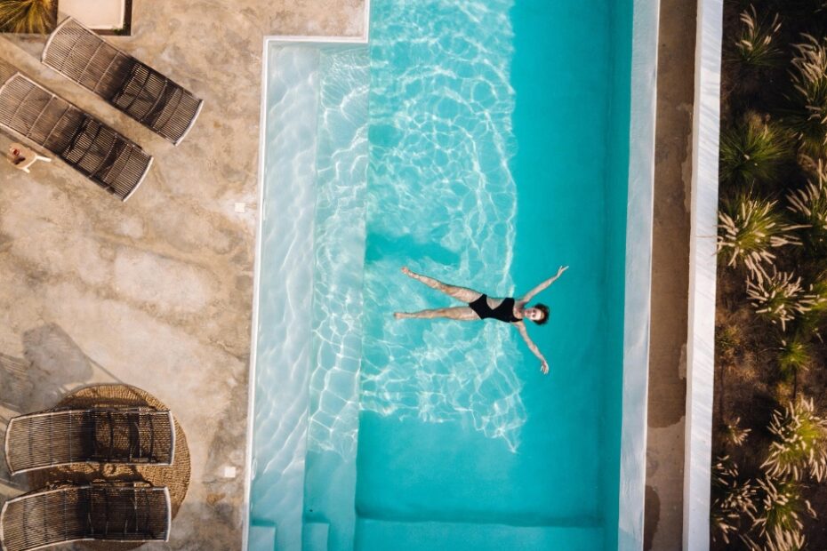 Área de lazer luxuosa exibindo uma piscina com borda infinita de água cristalina tratada com os melhores produtos para limpar piscina de 2026.