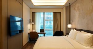 Quarto aconchegante com TV no quarto fixada na parede e iluminação suave, integrando design moderno e decoração em quarto pequeno.